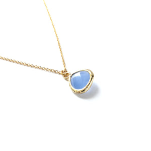 Gold plated framed ice blue faceted glass teardrop pendant on a gold plated chain necklace